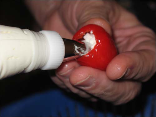 Piping the cheese into the peppadews